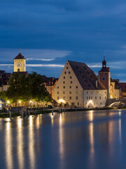 Town hall tower of Regensburg and Salzstadel on the banks of the Danube river with Stone Bridge at night