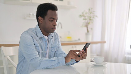 African Man using Smartphone at Home