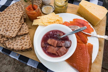 A Swedish summer meal of herring, crackers, salmon, potatoes, and cheese.