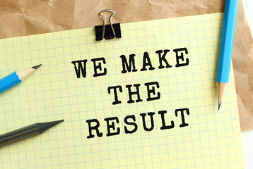 WE MAKE THE RESULT lettering on a yellow sheet of paper over crumpled kraft paper. Pencils and paper clip.