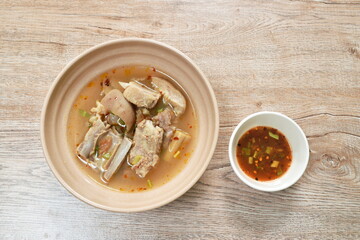 hot and spicy pork bone with tamarind and Thai herbs soup on bowl dipping chili sauce