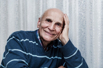 Obraz premium Confident cheerful adult man sitting at table and looking with smile