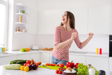 Portrait of attractive carefree cheerful girl dancing cooking useful tasty dish good mood at home light white kitchen indoors