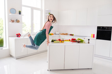 Full length photo of happy funny funky young woman jump weekend meal indoors inside house home kitchen