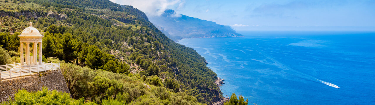 Temple of son marroig sits enthroned on the left side of the coastline of deia above the mediterranean sea in a dreamlike environment, ultra wide shot panorama, copy space at the right side, mallorca
