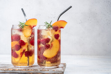 Delicious peach lemonade with soda water and raspberries. Fresh summer ice tea cocktail