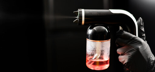 Close-up of instant tanning equipment in the hands of a master. Gun spraying paint for leather...