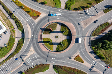 Aerial view of the transport interchange. Cars are moving on the roundabout over the pedestrian and bike paths. The modern design of the streets in Finland.