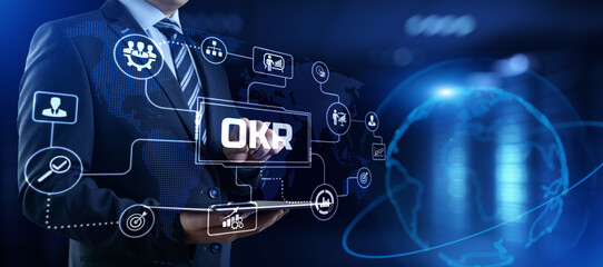 OKR Objectives key results. Businessman pressing button on screen.