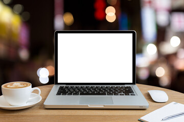 Fototapeta premium Laptop with blank screen on circle wooden table with mouse, a cup of coffee, notebook and pen, isolated on white.