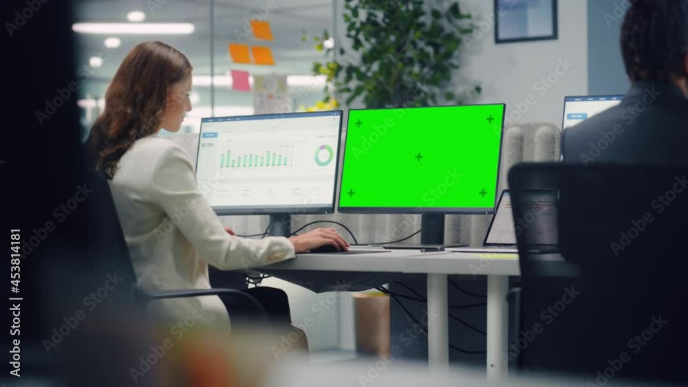 Poster young confident businesswoman using desktop computer with green screen mock up display in modern off
