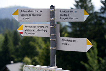 Sign post for direction of hiking trails  at local mountain Pfänder on a sunny summer day. Photo taken August 15th, 2021, Bregenz, Austria.