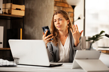 Girl at work, using her phone. Secretary answering calls. Manager at the office desk..