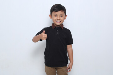 Asian boy wearing a black t-shirt showing his right thumb on white background. 