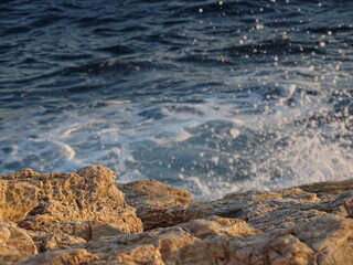 waves crashing on rocks during sunset  in mediterranean August 29  2021 