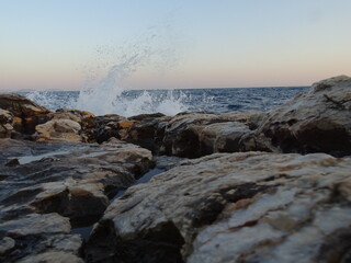 waves crashing on rocks during sunset  in mediterranean August 29  2021 