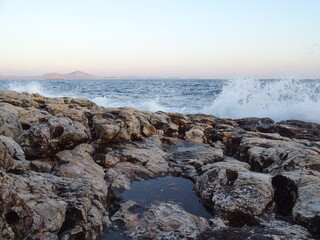 Fototapeta na wymiar waves crashing on rocks during sunset in mediterranean August 29 2021 