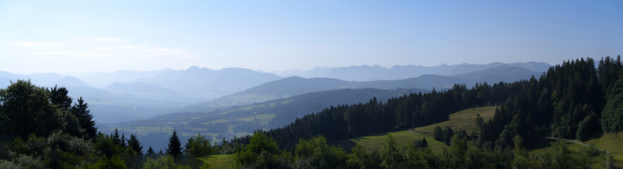Fototapeta na wymiar Beautiful wide angle scenic mountain panorama seen from local mountain Pfänder on a sunny summer day. Photo taken August 15th, 2021, Bregenz, Austria.