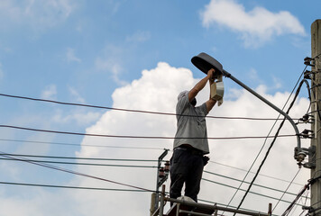 Electrician checking lighting to the LED street lamp post, Technician and maintenance service...