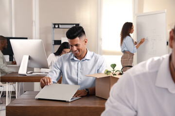 New coworker with laptop at workplace in office