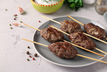 Traditional dish of Arab cuisine, grilled minced meat shish kebab on wooden skewers.