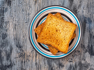 Two toasted toast on a small striped plate top view