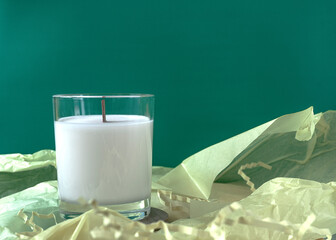 Candle standing on the wooden plate with wrapping paper