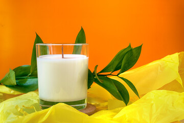 Candle standing on the wooden plate with wrapping paper