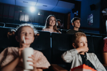Cheerful young couple in the cinema, watching film.