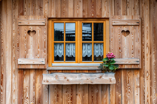 Fenster mit h&ouml;lzernen Fensterl&auml;den an einem rustikalen Bauernhaus
