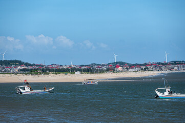 Obraz premium Beautiful fishing village, blue sky and white clouds, sea and small boats