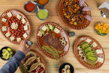 Mexican food served in clay dishes, on a wooden table