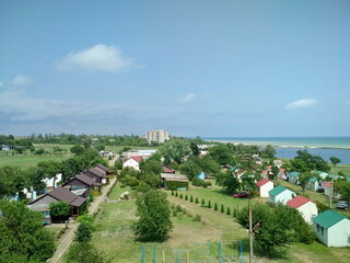 View from above on the endless streets of coastal resort houses against the background of boundless greenery of the Azov steppes.