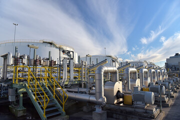 pipelines and buildings of a refinery - industrial plant for fuel production - obrazy, fototapety, plakaty