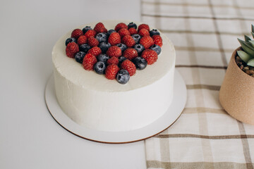 White cake with a heart of fruits. Valentine's Day.