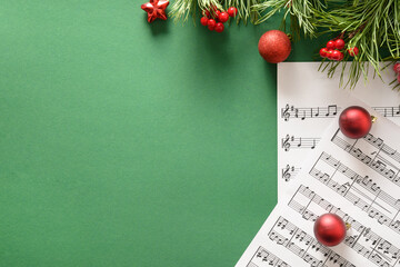 Music empty frame for Christmas Carols and sings decorated red balls on green background. View from...