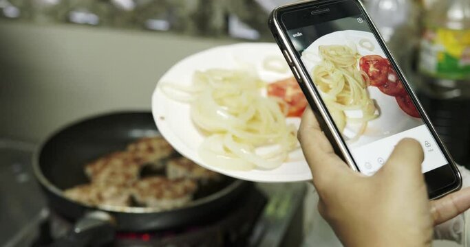 Close up of woman holds the modern smartphone and Take food pictures to share photos on social media resources.