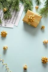 Music sheets for Christmas Carols and sings decorated golden balls on blue background. View from above. Vertical format.