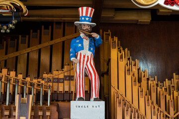 Landscape shot of an old antique american theme fairground organ in red white blue and gold colours called Whistlin Dixie. Uncle Sam figure stands and conducts the organ