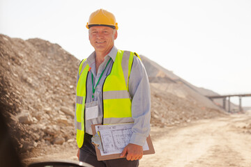 Businessman and worker reading blueprints on site