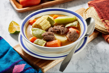 Mole de olla, red beef broth with meat, carrot, corn, pumpkin, potato, traditional Mexican dish