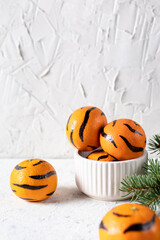 Tangerines with painted stripes. The concept for the tiger new year with a Christmas tree. Tiger mandarines