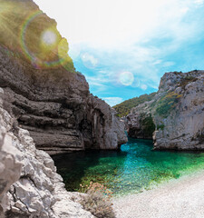 Beautiful beach Stiniva on the island of Vis, Croatia. No people on a beautiful summer day. Hidden gems, one of the highlights of the croatian coast. Teal green adriatic sea. Sun flare of the lens