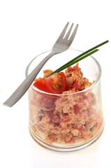 Verrine d'oeufs brouillés avec de la ciboulette et une fourchette en gros plan sur fond blanc