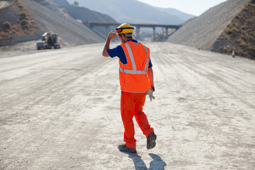 Fototapeta premium Worker standing by machinery on site
