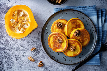 Pumpkin pancakes with walnuts and caramel sauce in a plate