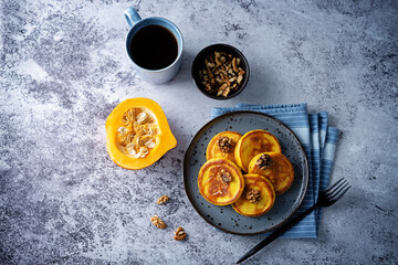 Pumpkin pancakes with walnuts and caramel sauce in a plate