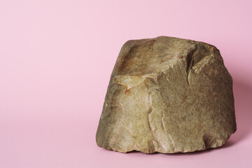 Creative stone podium for cosmetics or products on pink background.