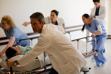 Doctors rushing patient on gurney in hospital corridor