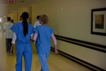 Doctors and nurses walking down hospital corridor